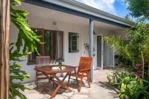 a patio with a wooden table and two chairs at Lagoon Point Lodge in Knysna