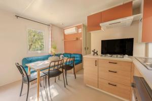 a kitchen and a dining room with a table and chairs at Camping 4 étoiles - Piscine - ccbfiee in Olmeto