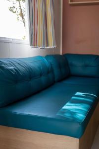 a blue couch in a room with a window at Camping 4 étoiles - Piscine - ccbfiee in Olmeto +16 photos
