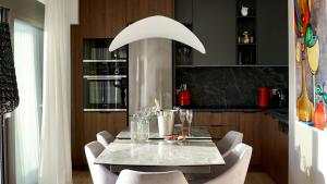 a dining room with a table and chairs and a kitchen at Alimos Escape 3 in Athens
