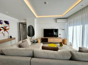 a living room with a couch and a flat screen tv at Alimos Escape 3 in Athens +30 photos
