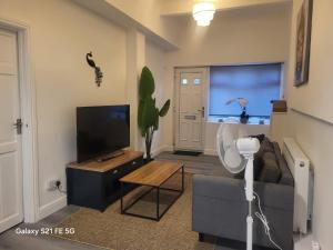 a living room with a couch and a flat screen tv at Perfectspot in Tilbury +3 photos