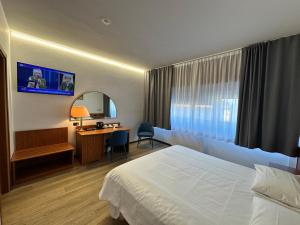 a hotel room with a bed and a desk at Hotel Cristallo in Udine