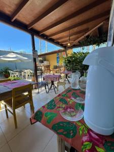 a patio with tables and chairs and a table with at Pousada Casa Meraki in São Sebastião