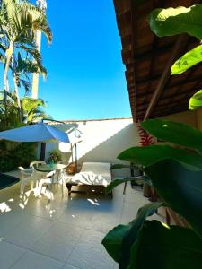 a patio with a table and chairs and an umbrella at Pousada Casa Meraki in São Sebastião +6 photos
