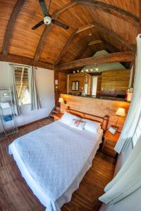 a bedroom with a large bed with a wooden ceiling at Eco Venao Lodge, Playa Venao in Playa Venao