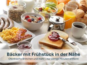 a breakfast table with a plate of breakfast foods at Haus Klipper - Nordseebad Burhave in Burhave