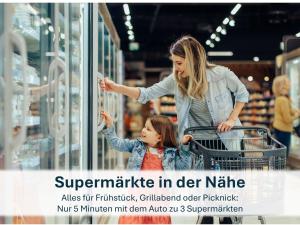 a woman pushing a child in a shopping cart in a store at Haus Klipper - Nordseebad Burhave in Burhave