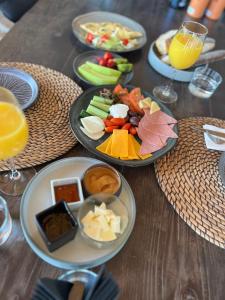 a table with plates of food and glasses of orange juice at Egee Guest House in Nea Peramos
