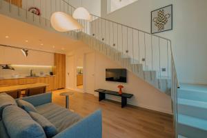 a living room with a couch and a staircase at Artifact Apart Hotel in Tbilisi City