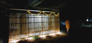 a person walking past a fence at night at Free People Camping in Vama Veche
