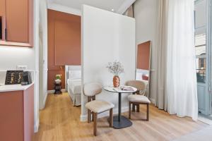 a kitchen and dining room with a table and chairs at Hospi Living Empire Suites in Heraklio