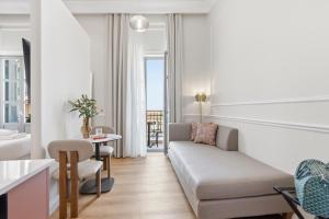 a living room with a couch and a table at Hospi Living Empire Suites in Heraklio +49 photos