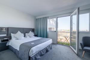 a hotel room with a bed and a balcony at Holiday Inn Calais - Centre Car Ferry by IHG in Calais
