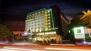 a lit up building on a city street at night at Holiday Inn Bandung Pasteur, an IHG Hotel in Bandung