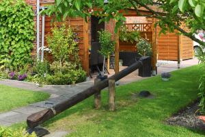 a wooden rail in the yard of a garden at Ferienwohnungen Haus Saathoff in Bensersiel