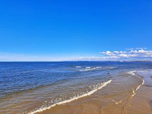 a sandy beach with waves in the ocean at Ferienzimmer Gleißner in Ahlbeck