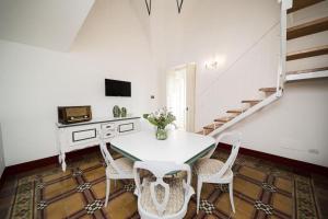 a white dining room with a table and chairs at Matinè Suite And Room in Matino