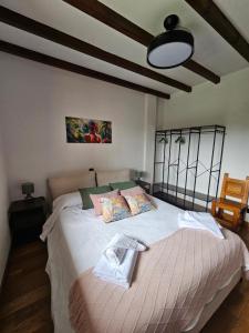a bedroom with a large bed with white sheets at Casa Gelín Verde in Santillana del Mar