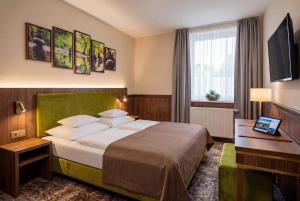 a hotel room with a bed and a television at Hotel Dolce Vita in Balatonkenese