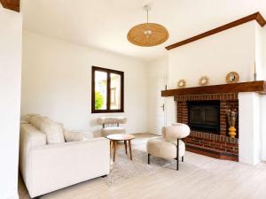 a living room with a white couch and a fireplace at Villa 1h30 de Paris - Padel - Piscine - 7 ch - 22 pers in Épinay +25 photos