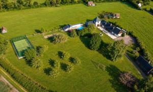 an aerial view of a house on a green field at Villa 1h30 de Paris - Padel - Piscine - 7 ch - 22 pers in Épinay