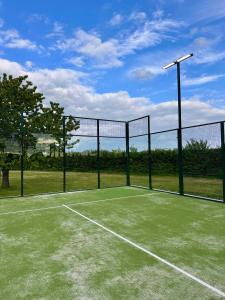 a tennis court with a net on top of it at Villa 1h30 de Paris - Padel - Piscine - 7 ch - 22 pers in Épinay
