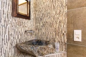 a bathroom with a stone tub in a tiled wall at Domaine du chemin Royale in Saint-Germain