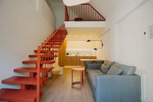 a living room with a couch and a staircase at Artifact Apart Hotel in Tbilisi City