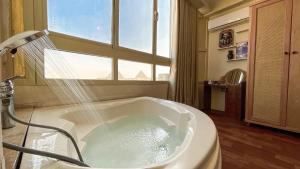 a bath tub in a bathroom with a window at luxurios hotel with pyramids view in Cairo +285 photos