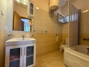 a bathroom with a sink and a toilet and a mirror at S Pearl Lux in Utjeha