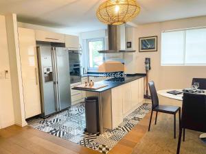 a kitchen with a refrigerator and a table in it at Appt Ortolans - Hossegor centre - Terrasse - Park in Hossegor