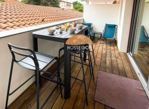 a black table and chairs on a balcony at Appt Ortolans - Hossegor centre - Terrasse - Park in Hossegor