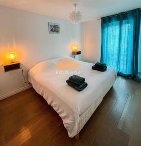 a bedroom with a bed with two bags on it at Appt Ortolans - Hossegor centre - Terrasse - Park in Hossegor