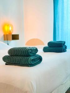 three stacks of pillows sitting on top of a bed at Appt Ortolans - Hossegor centre - Terrasse - Park in Hossegor +7 photos