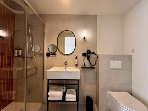a bathroom with a sink and a shower and a mirror at Hôtel des quatre saisons in Guérande +36 photos