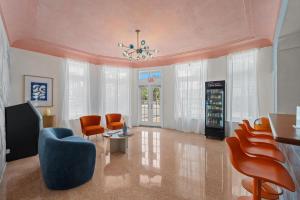 a living room with orange chairs and a soda machine at Blue Flamingo Suites in Miami Beach