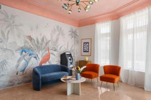 a living room with a blue couch and two chairs at Blue Flamingo Suites in Miami Beach