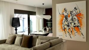 a living room with a couch and a painting on the wall at Alimos Escape 3 in Athens