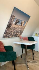 a room with a table and two green chairs at Logies La Dune Westende-Bad - Gratis parking in Middelkerke +7 photos