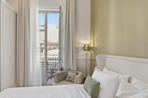 a hotel room with a bed and a balcony at Hospi Living Empire Suites in Heraklio