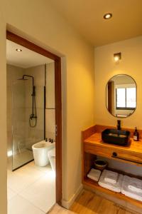 a bathroom with a sink and a toilet and a mirror at Alma de Purmamarca in Purmamarca +27 photos