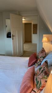 a bedroom with a bed with pillows on it at Logies La Dune Westende-Bad - Gratis parking in Middelkerke