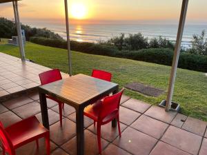 a table and chairs with a view of the ocean at 3 Eden Sands in Kingsborough