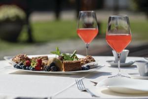 two glasses of wine and a plate of food on a table at La Colombera Ristorante - Albergo in Castrezatto