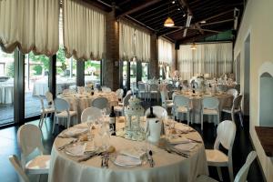 a banquet hall with white tables and chairs at La Colombera Ristorante - Albergo in Castrezatto
