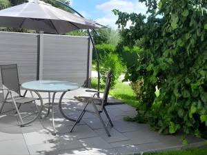 a patio with a table and an umbrella at Peene Alte Schule Völschow Dornberger in Völschow