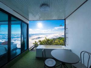 a bathroom with a large window with a tub and a table at The Forest View ภูทับเบิก in Ban Maeo Thap Boek