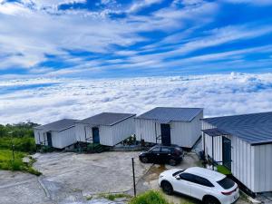 a car parked in front of a row of buildings above the clouds at The Forest View ภูทับเบิก in Ban Maeo Thap Boek