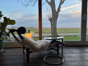 a chair with a hat sitting next to a table at Over Lake in Monnickendam